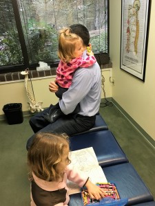 Dr. Cummins adjusting his own children at Bellevue's Cummins Chiropractic.  