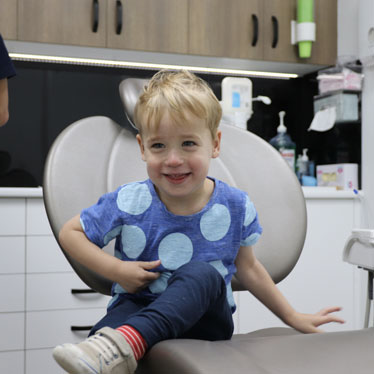 Boy at children's dentist receiving dental hygiene for kids