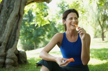 Woman eating carrots.