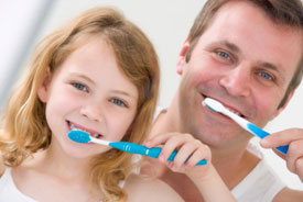 Father and daughter brushing together