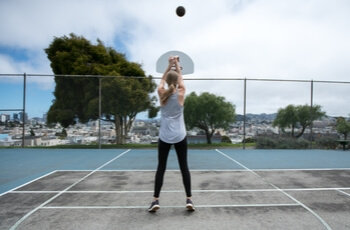 Woman shooting basketball.