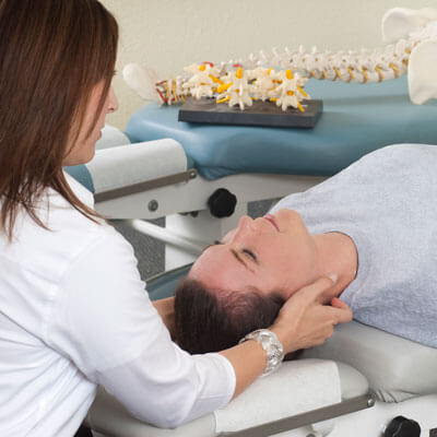 Female chiropractor adjusting patient