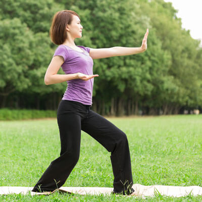 woman doing tai chi in the park