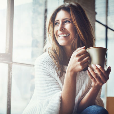 woman drinking coffee and smiling 