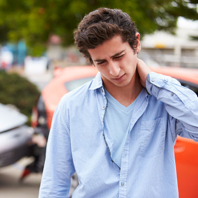 young man holding neck after car wreck